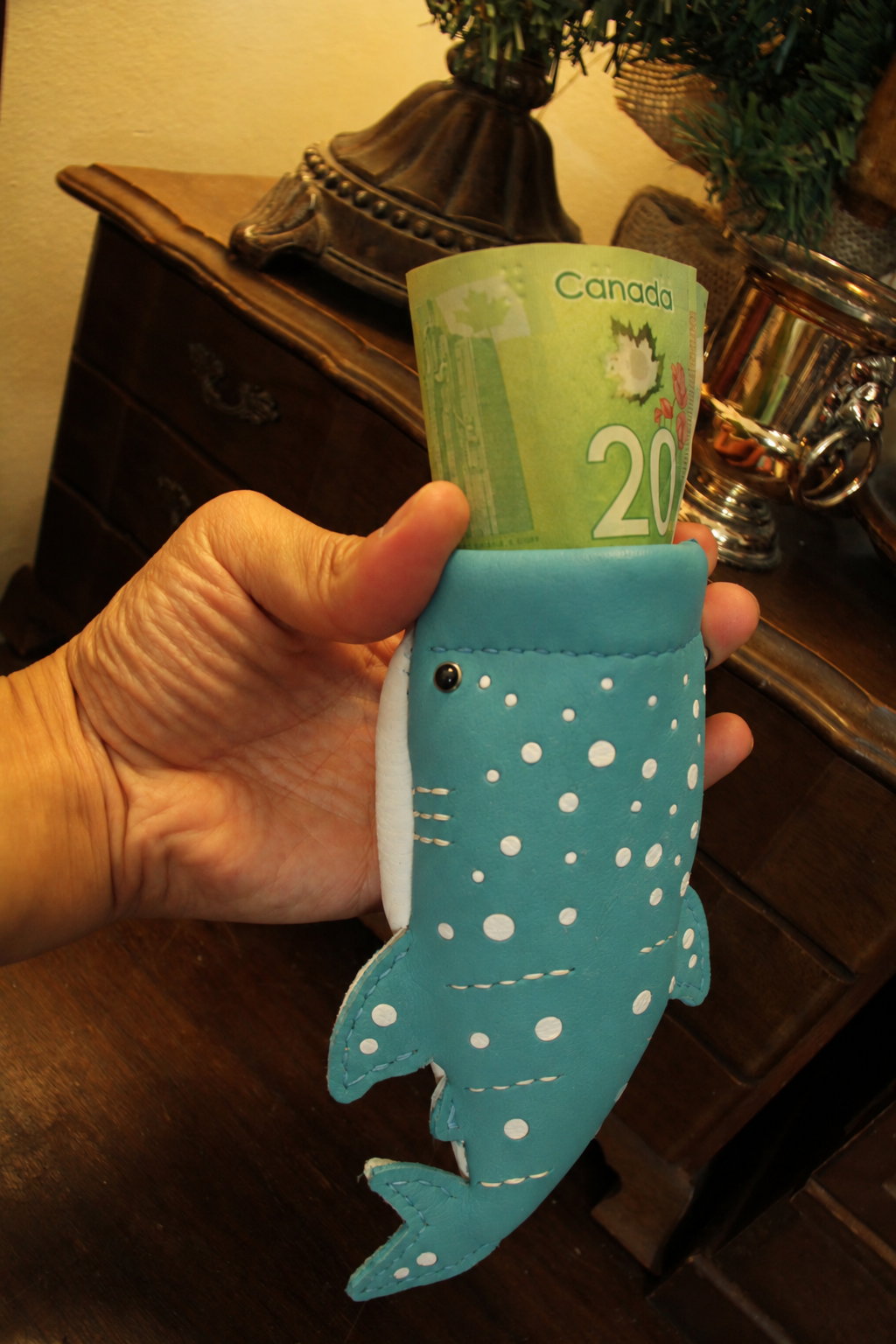 Baby Whale Shark Wallet held in a hand with folded banknotes inside