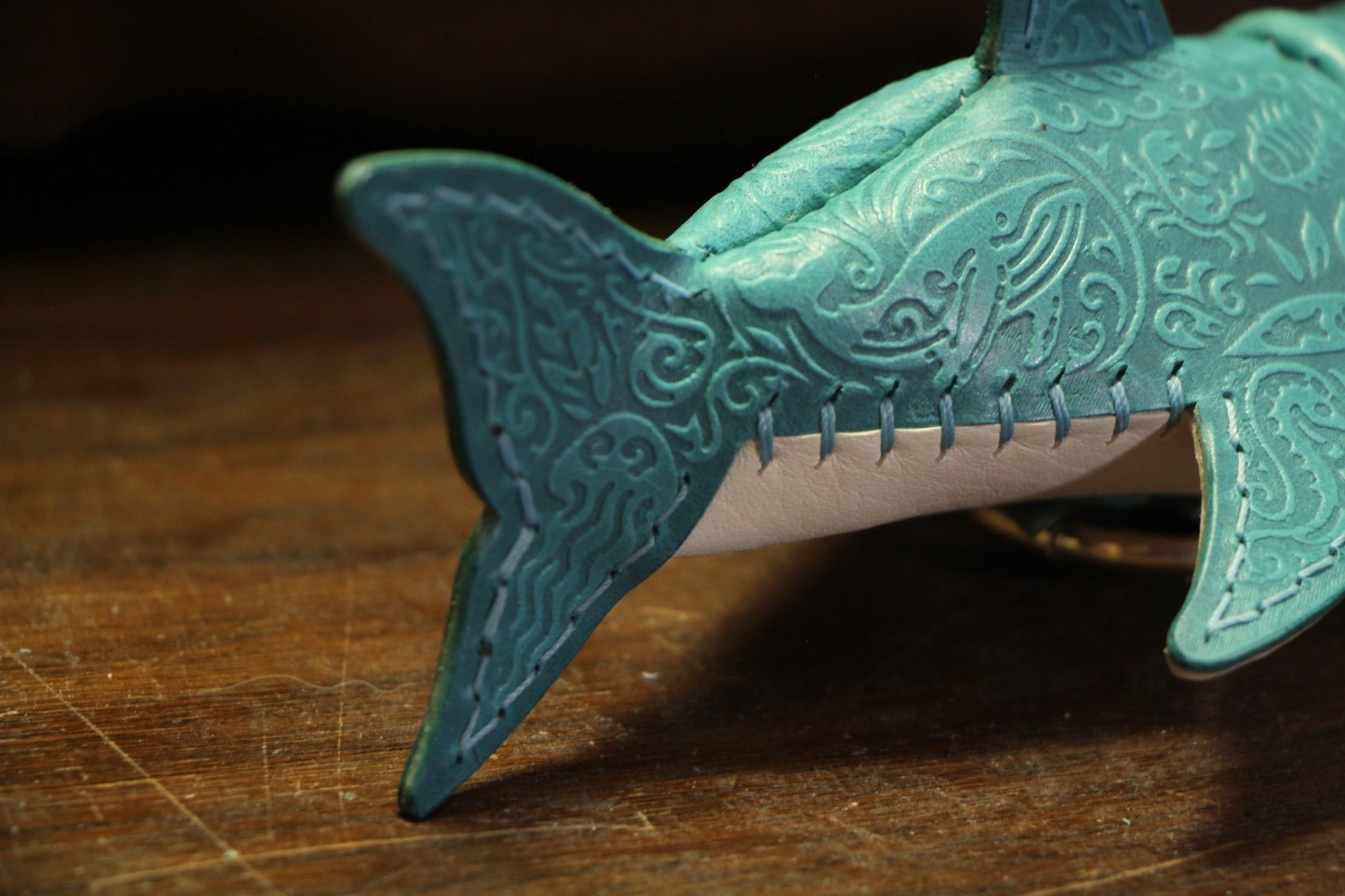 Embossed detail on shark tail and leather stitching